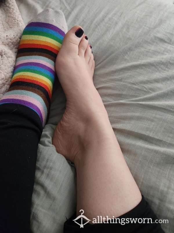 Bare Feet Coming Out Of Rainbow Socks