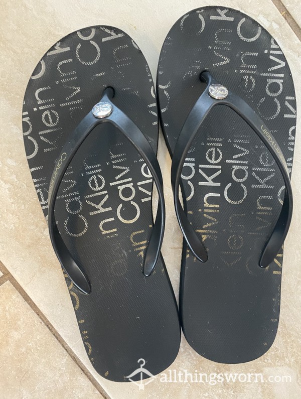 Worn Black Calvin Klein Flip Flops With Footprints
